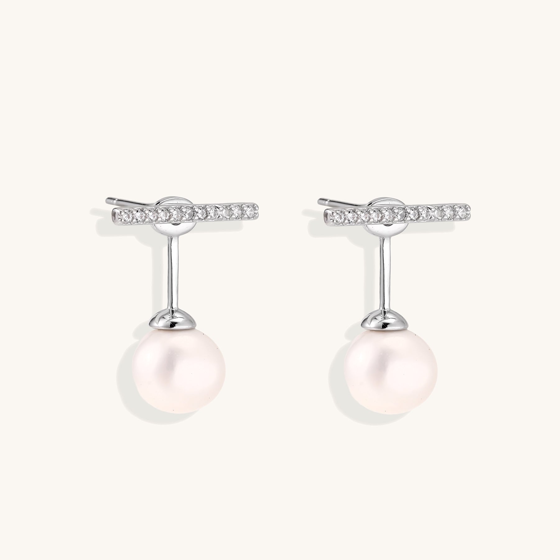 Sterling silver bar stud earrings with freshwater pearl drops on white background, minimalist jewelry design