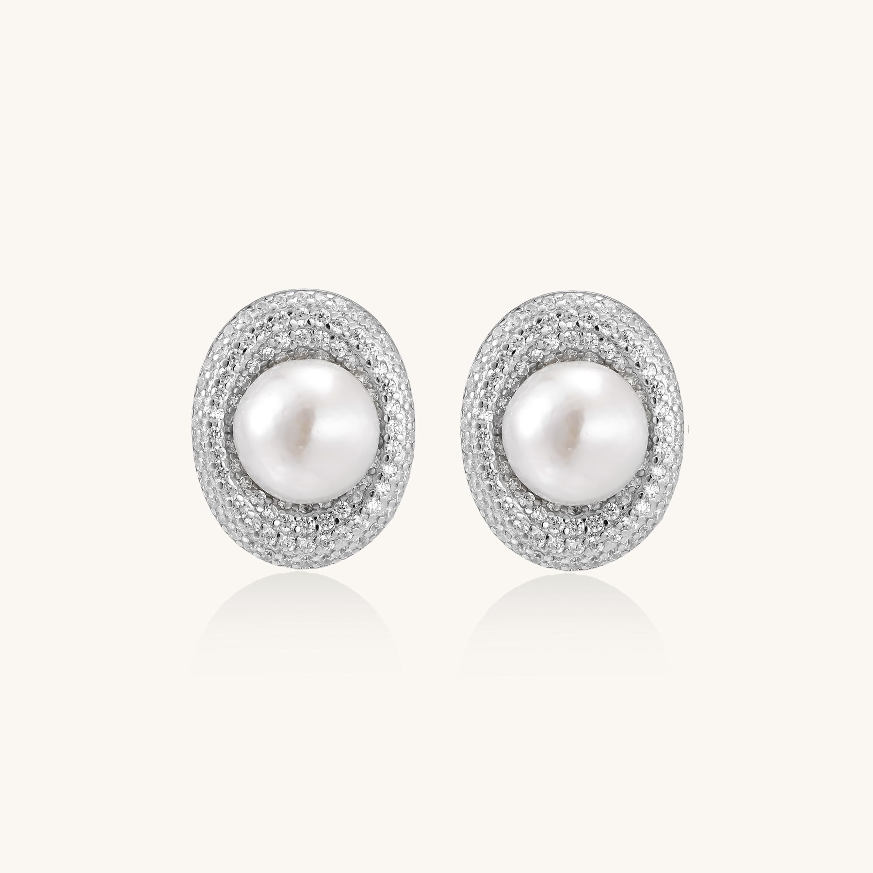 Sterling silver stud earrings with freshwater pearls surrounded by sparkling pavé crystals on white background.