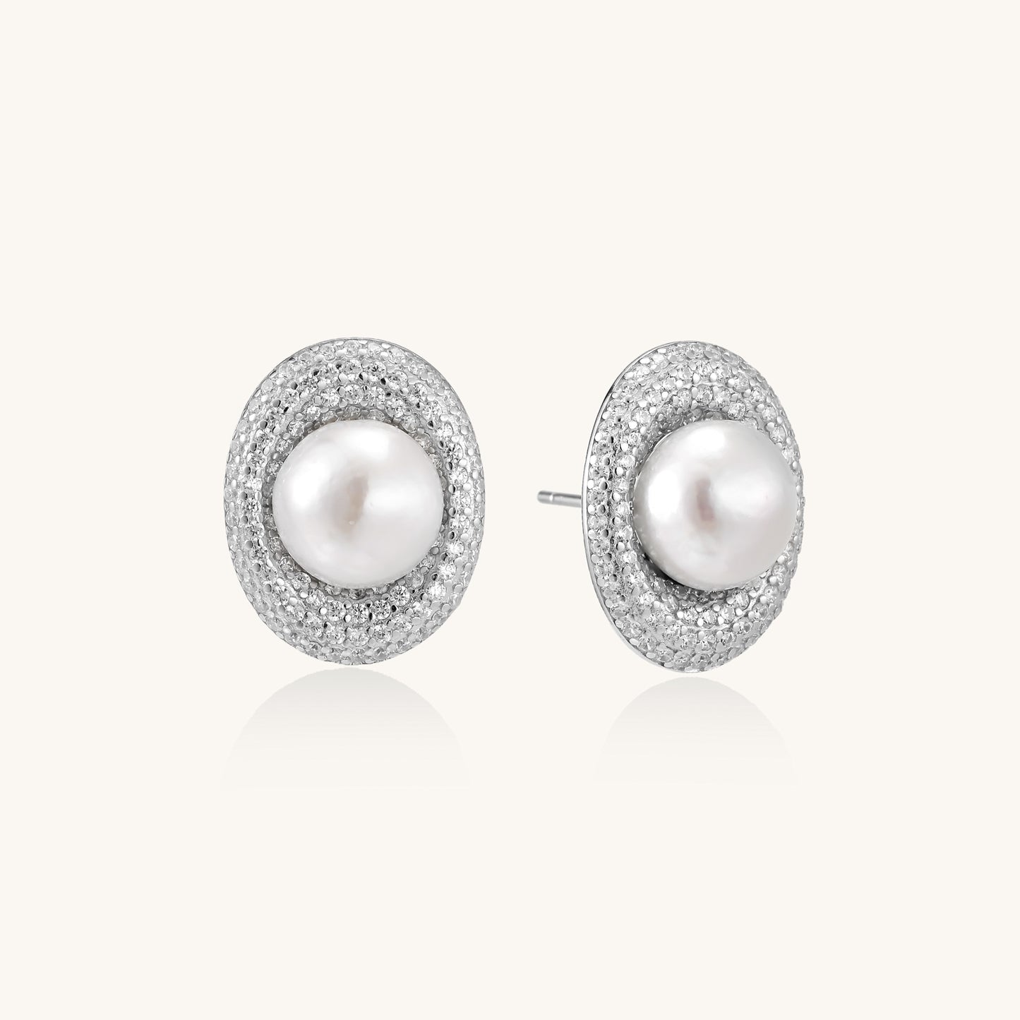 Sterling silver stud earrings with freshwater pearls surrounded by sparkling pavé crystals on white background.