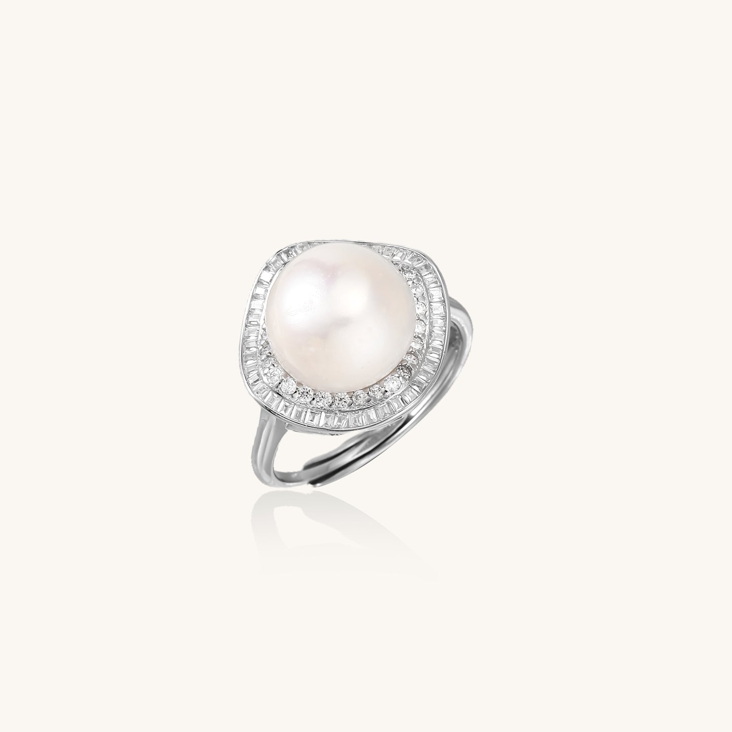Sterling silver ring with 11mm freshwater pearl surrounded by double diamond halo on white background.