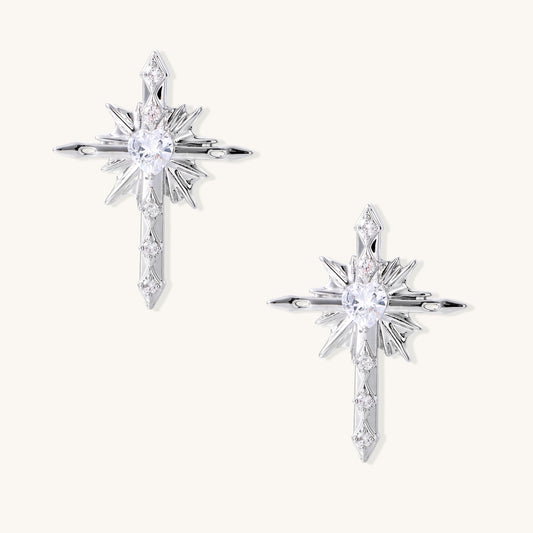 Gold-plated brass starburst cross earrings with central zirconia stones on white background.