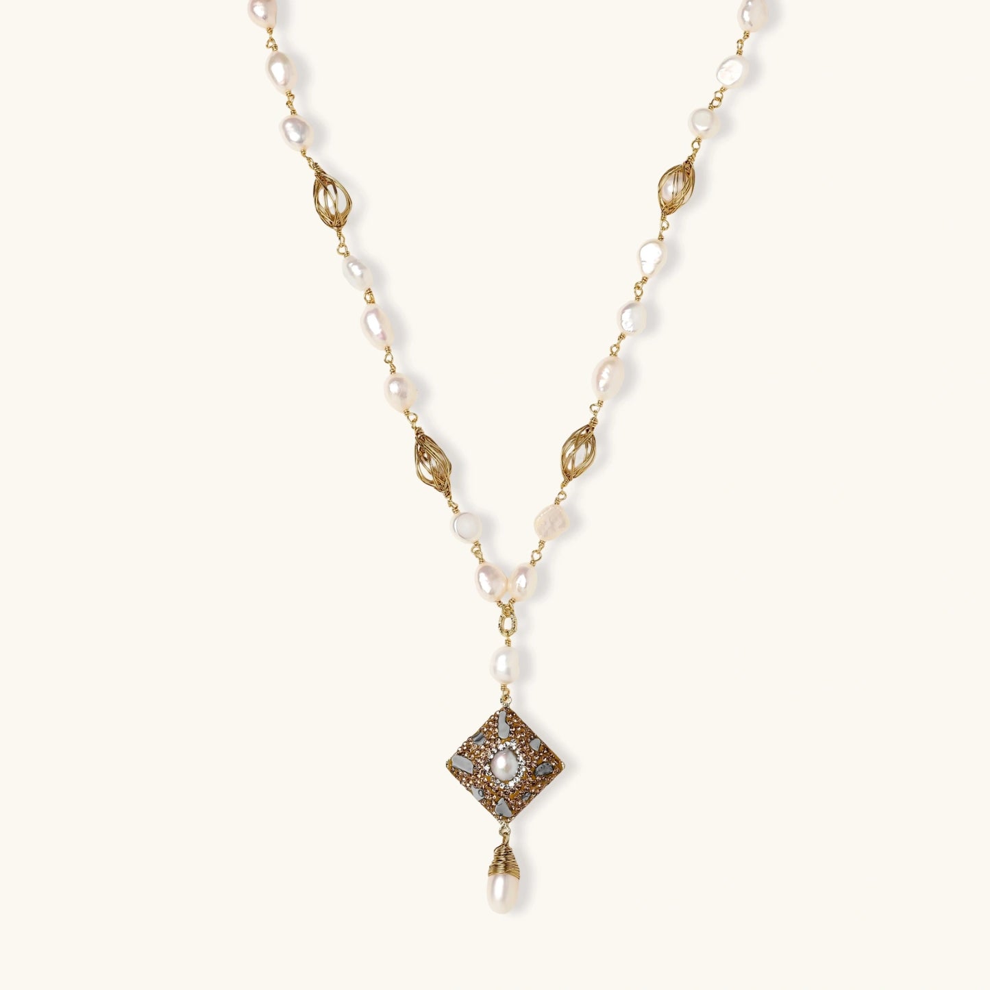 Y-shaped necklace with freshwater pearls, gold filigree stations, and ornate diamond-shaped centerpiece with pearl drop
